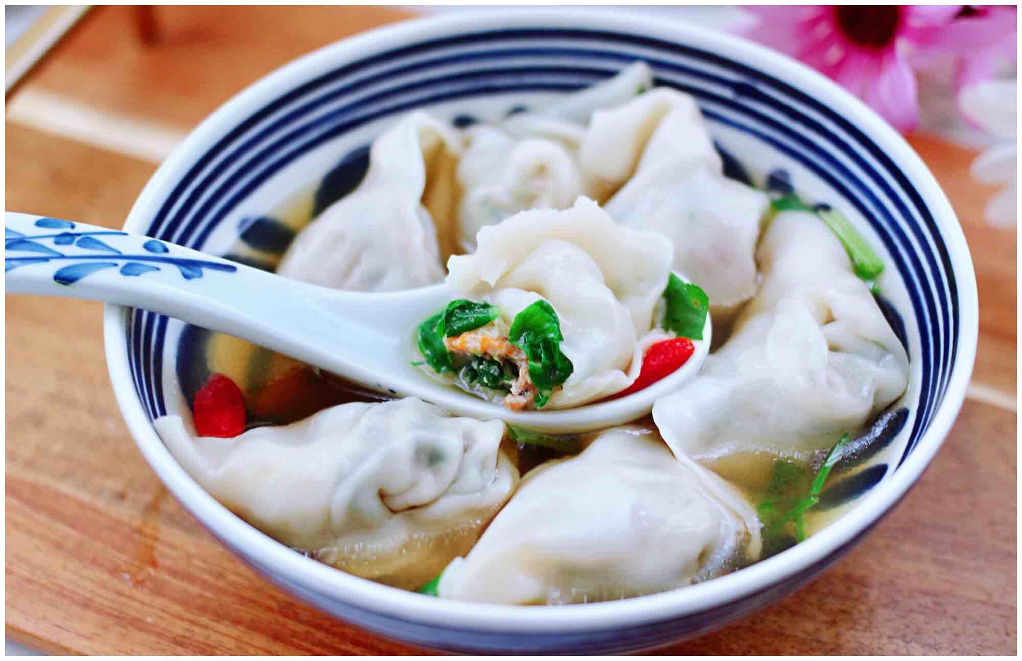 碗里加入少许生抽和芝麻油,撒上点香菜段和枸杞,把煮好的馄饨放入碗中