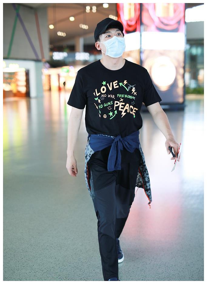 他穿着印花恤,把外套系腰间潮流范足,雄赳赳甩臂疾走,脚下生风自带