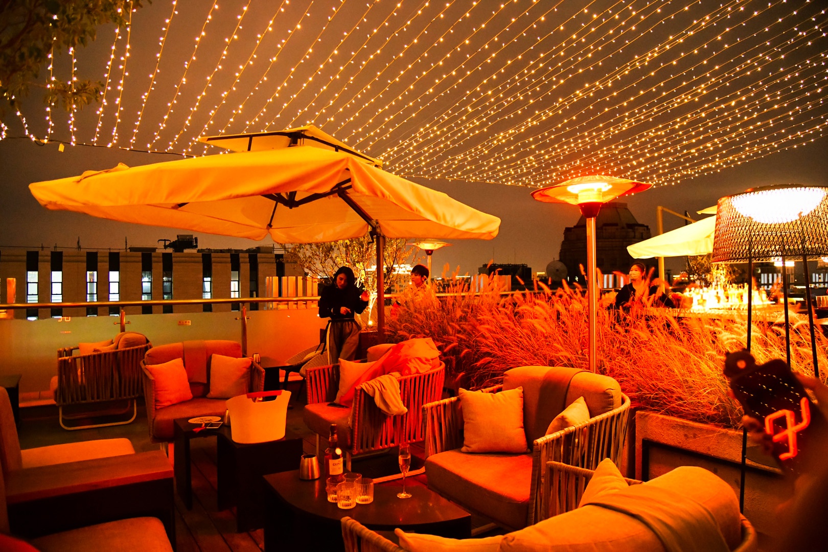 在新世界酒店屋顶露台酒吧"印",享用美酒和馨飞亚藤编家具