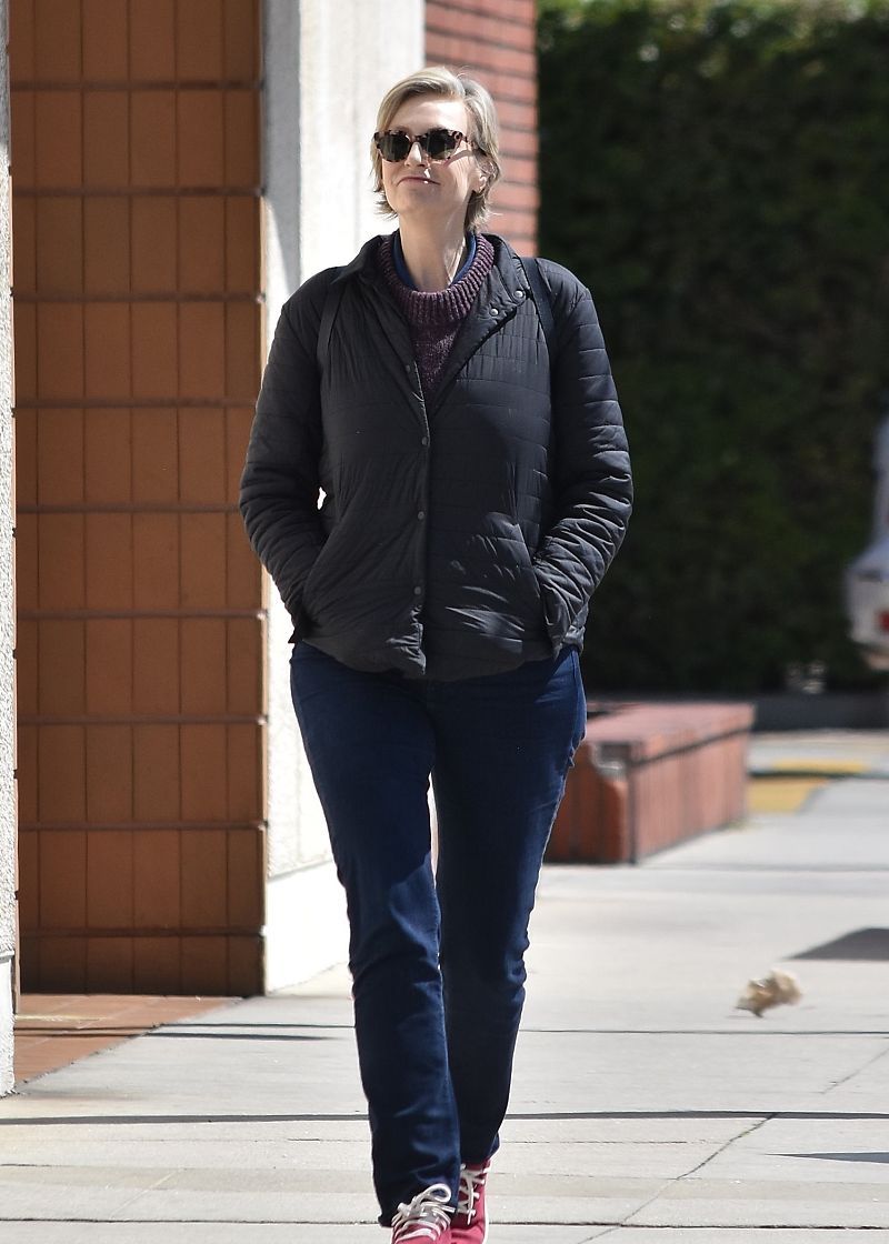 简·林奇街拍:薄羽绒服牛仔裤红色休闲鞋气场十足