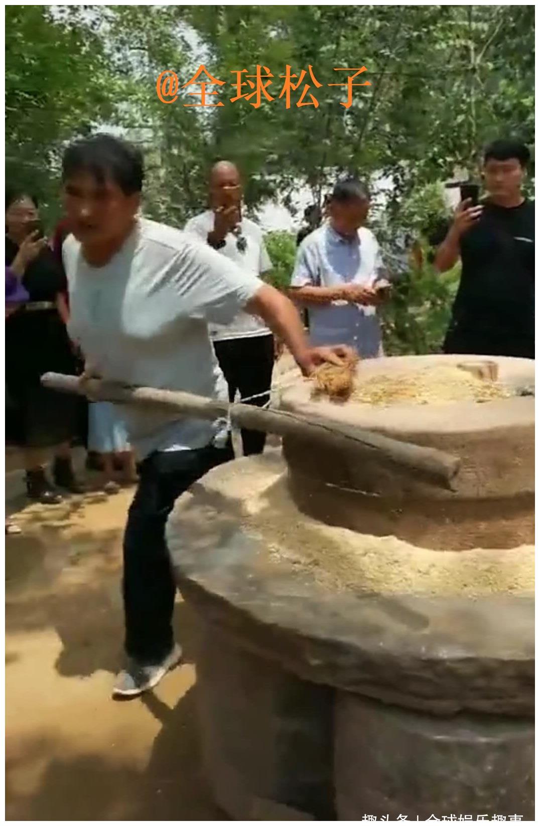 大衣哥使用人工"推磨"引围观,不惧夏天炎热磨面粉