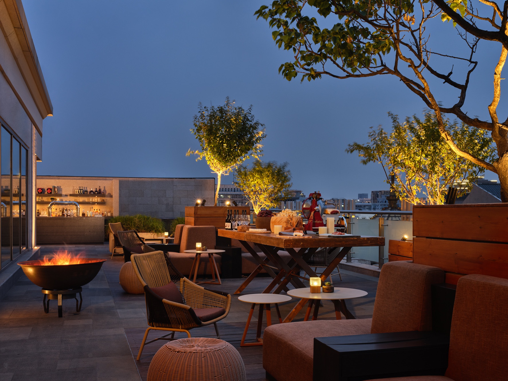 在新世界酒店屋顶露台酒吧"印",享用美酒和馨飞亚藤编家具