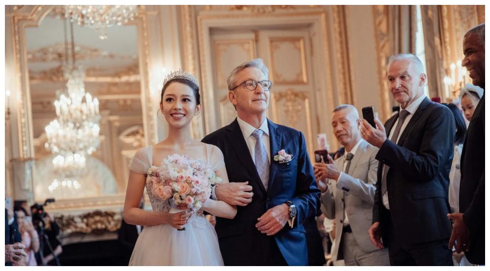 当天吉娜身穿白色纱裙,头戴皇冠温柔且甜美,爸爸西装革履,帅气感爆棚