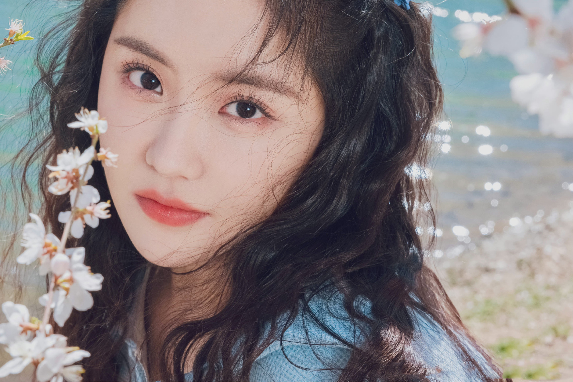 王艺瑾一身蓝色翻领套装,在粉色樱花的映衬下显得甜美