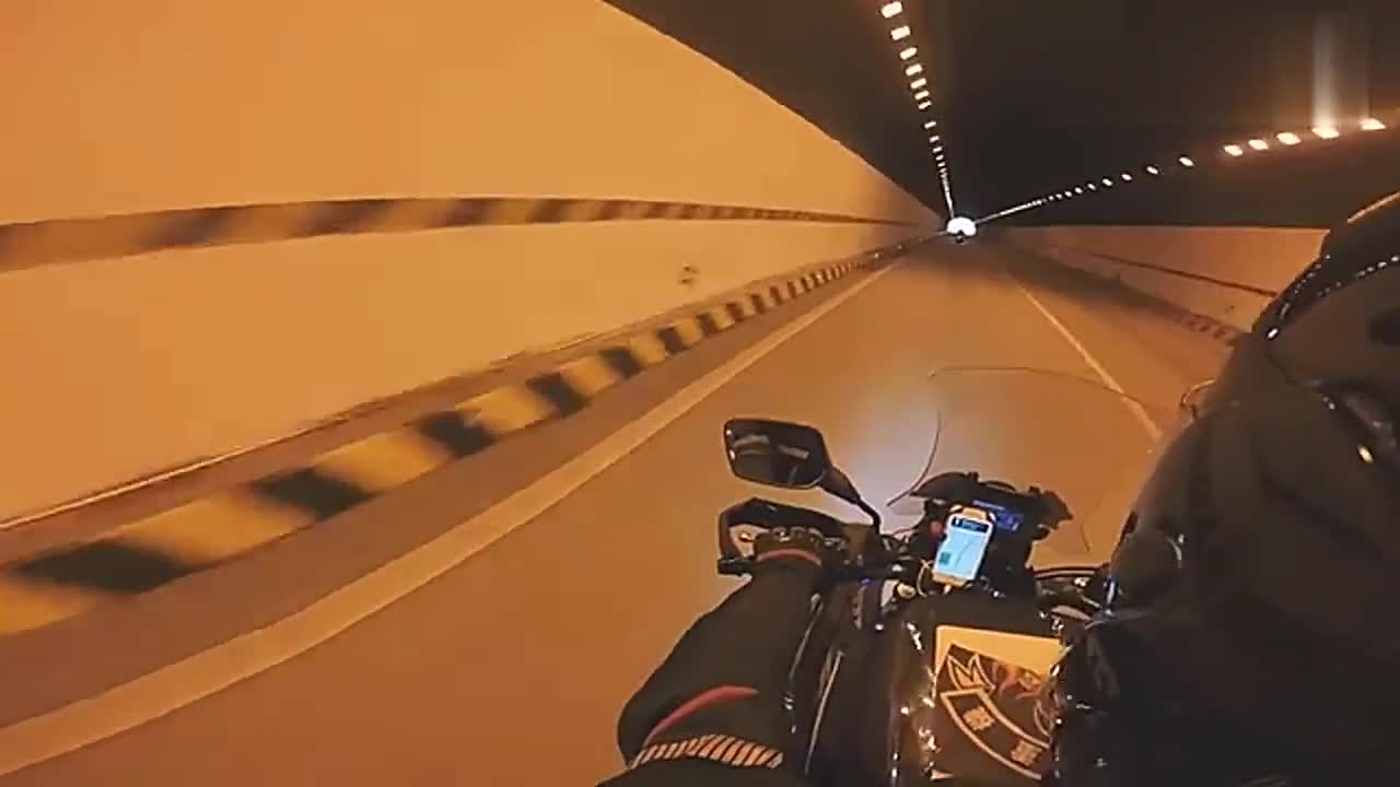 机车手骑摩托车穿过隧道,一路前行