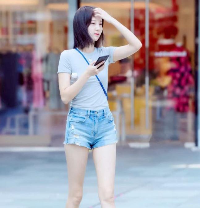 街拍身穿灰色t恤搭牛仔短裤美女你是刚刚起床没睡醒吗