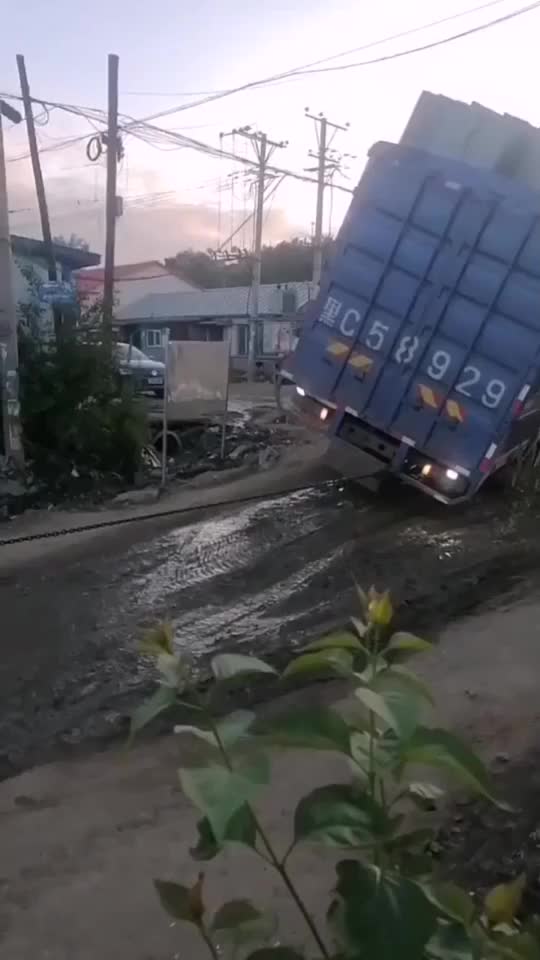 大货车拉着一车货陷坑里，装载机使劲拉才把它拉出来！