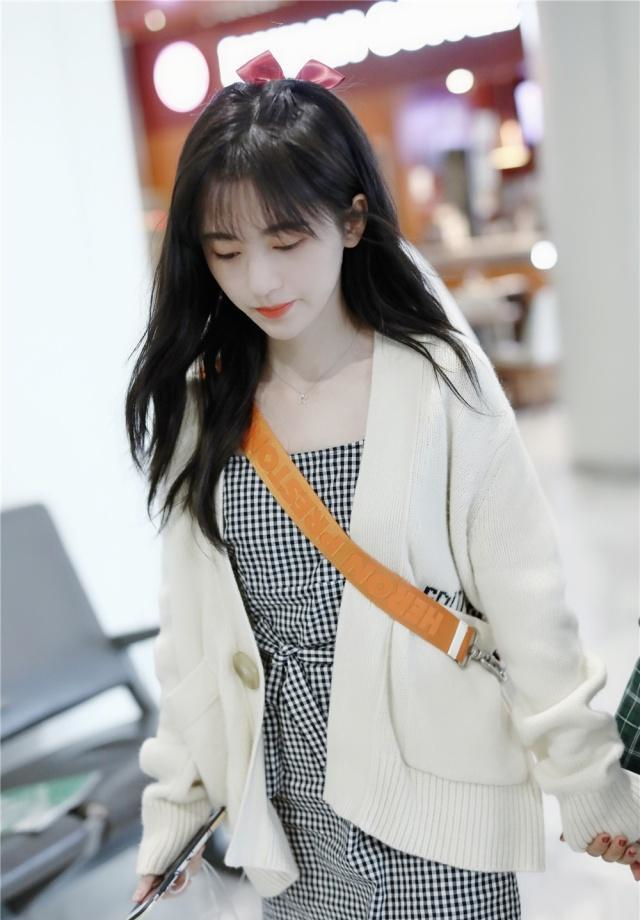 就像图中,在机场鞠婧祎上身是一件非常简单的红色t恤,下身搭配的是