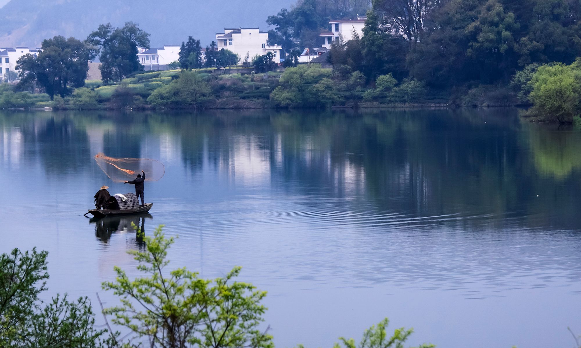 春风又绿江南,渔夫在湖中打鱼,一幅中国古代水墨山水画