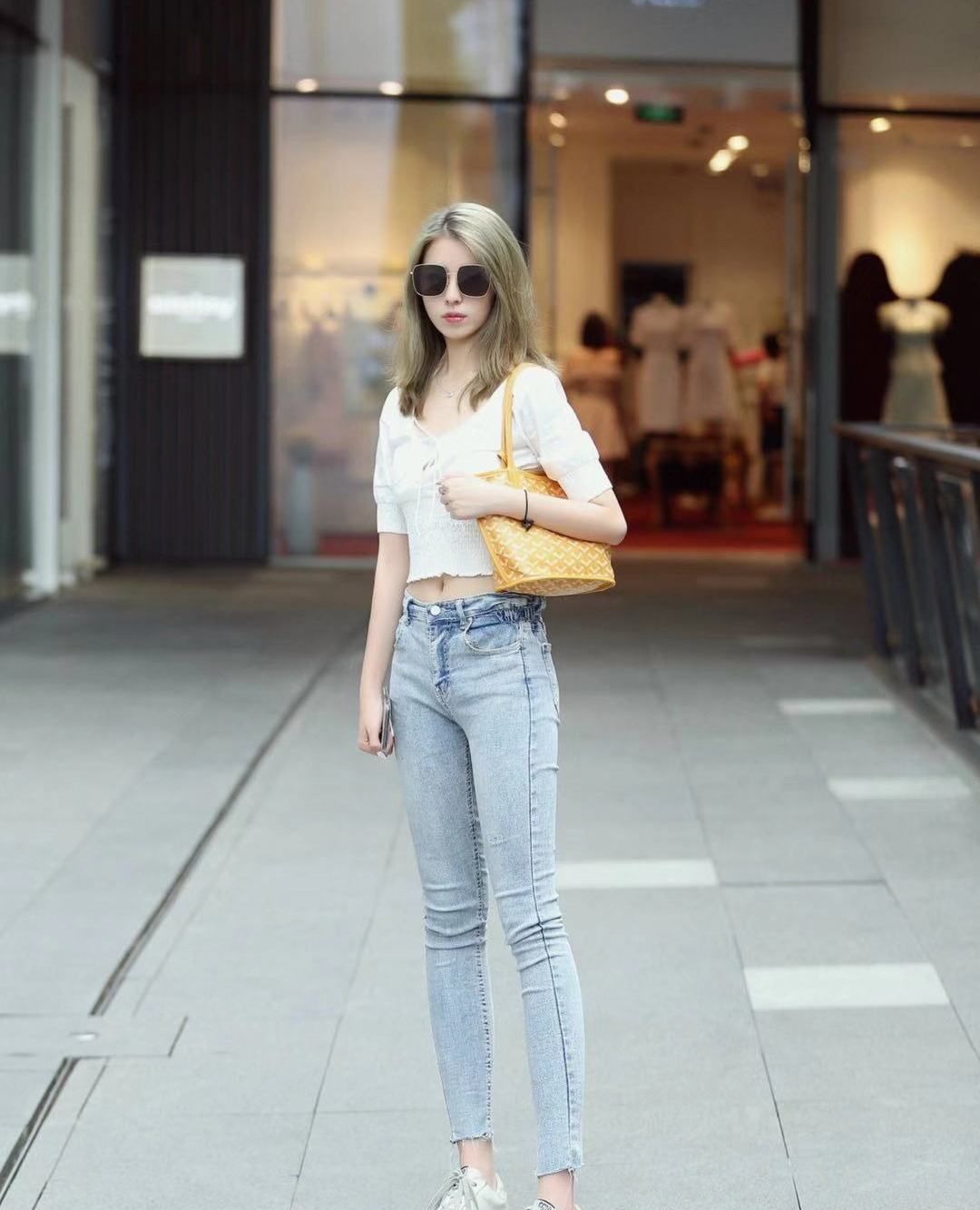 街拍,小姐姐白色露脐上衣搭配紧身牛仔裤,脸戴墨镜气场十足