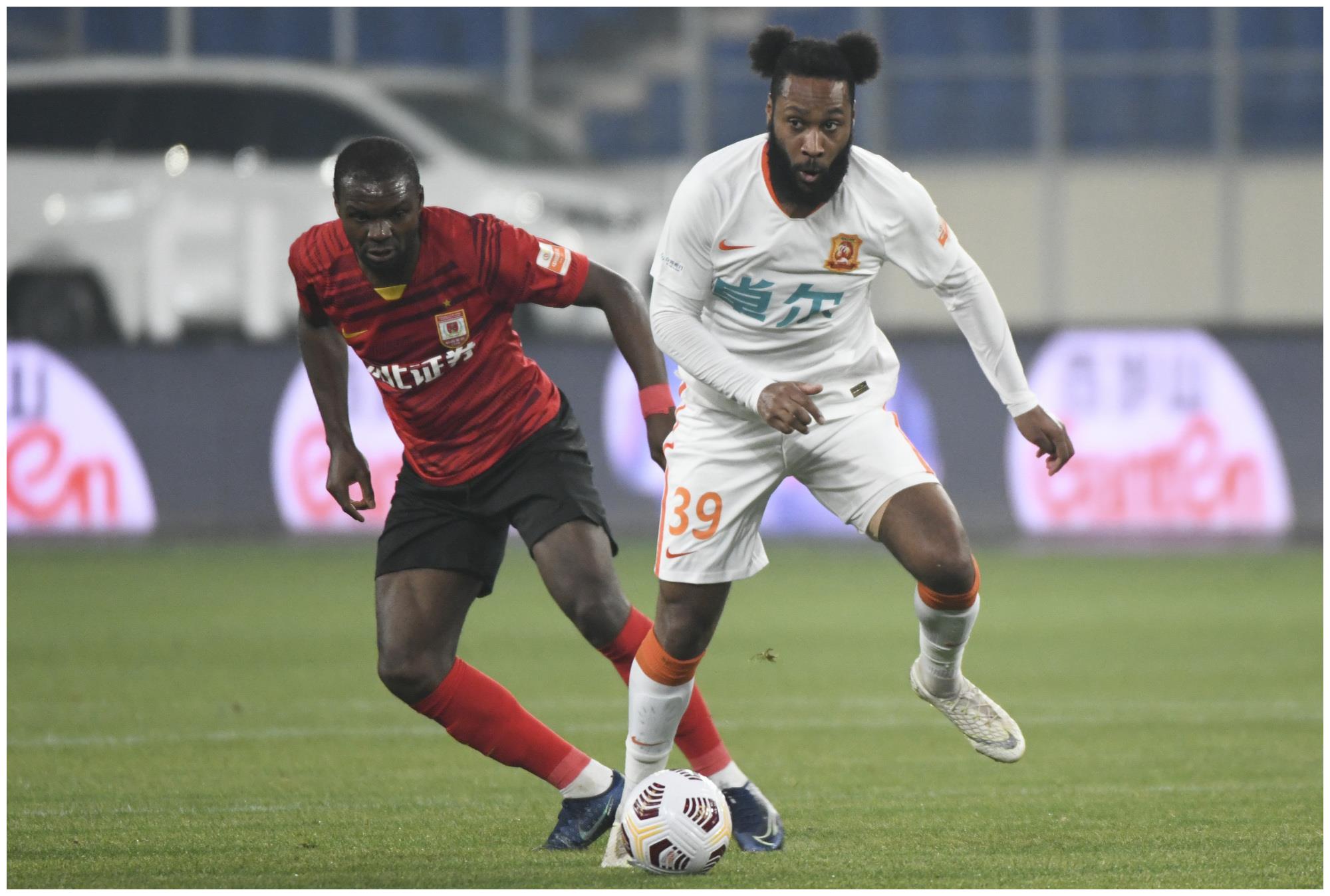 5月4日,武汉队球员阿金(右)与长春亚泰队球员奥克雷在比赛中拼抢.