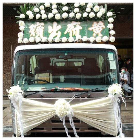 通过现场照片来看,灵车用白色的菊花装点,与灵堂的布置相呼应,牌匾上