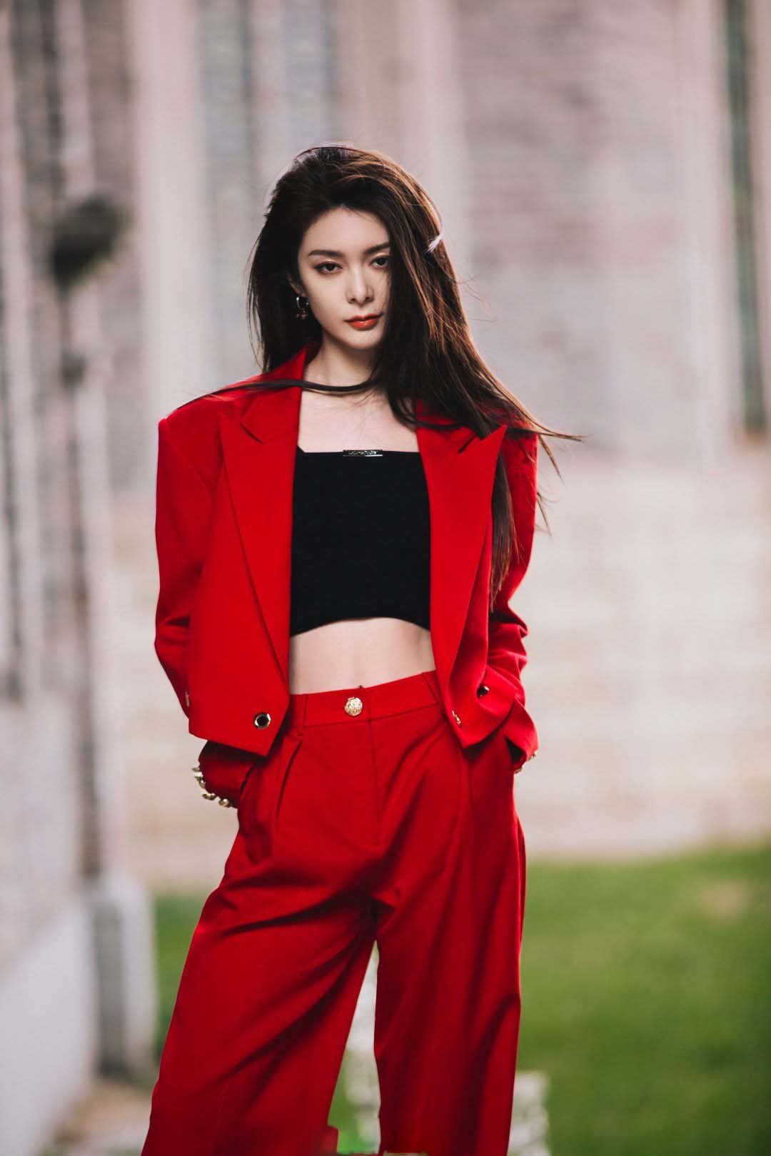 傅菁身着红色西装,正红色与青砖的配色尽显高级质感__财经头条