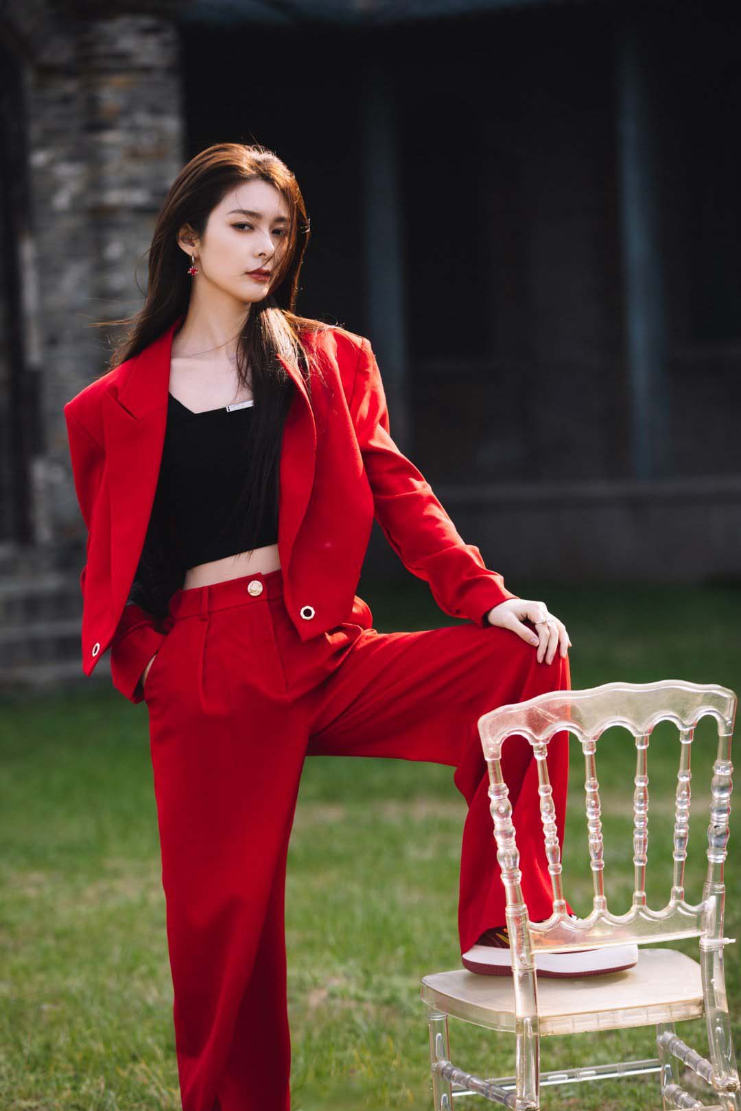 傅菁身着红色西装,正红色与青砖的配色尽显高级质感__财经头条