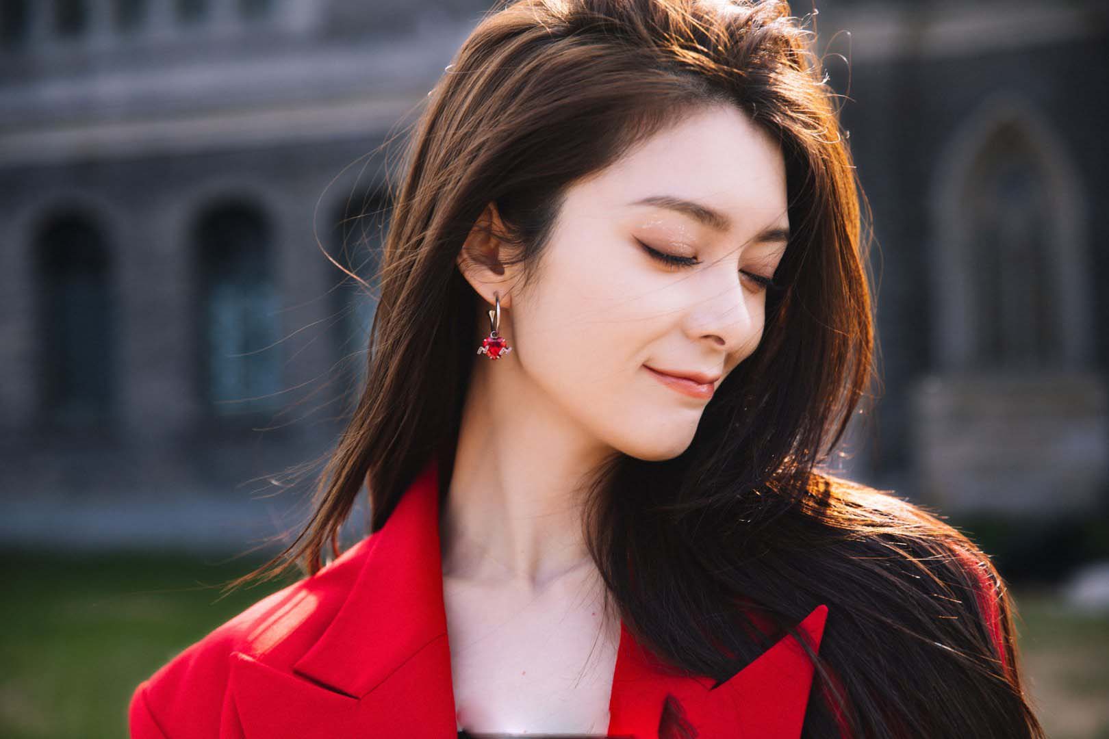 傅菁身着红色西装,正红色与青砖的配色尽显高级质感__财经头条