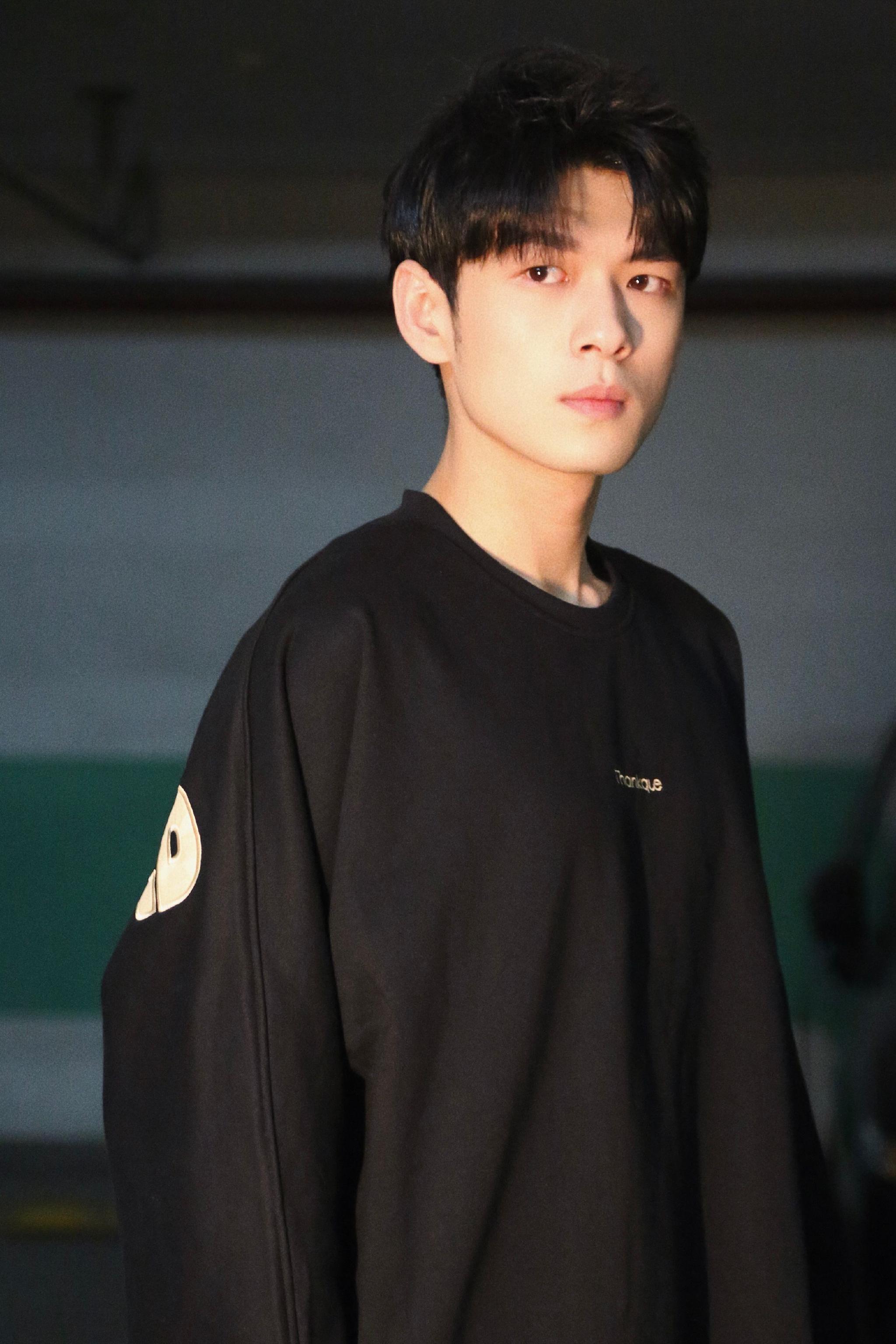 照片中的盛英豪整体穿搭以黑色作为主色调,白色英文印花在此基础之余