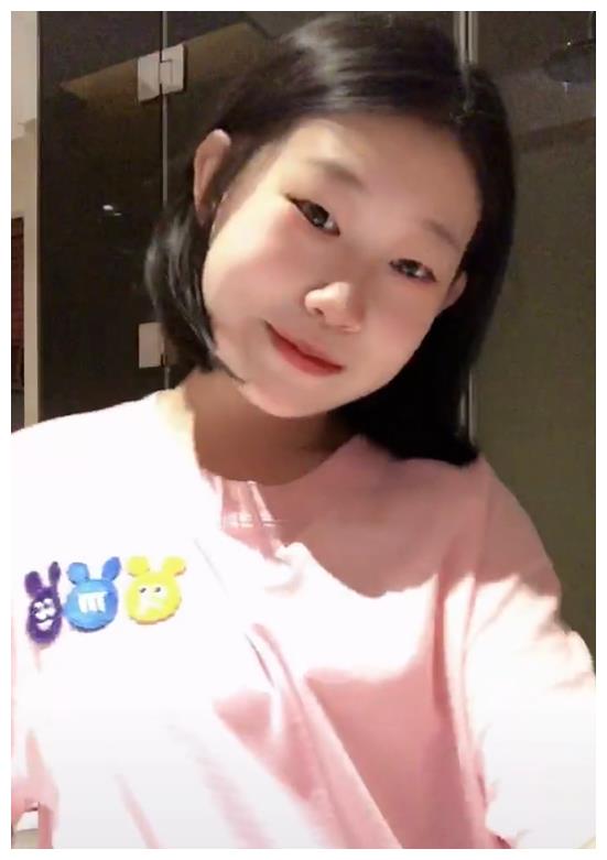 14岁的沈佳润剪短头发后,充满少女气息.她穿着粉红色的t恤衫在家跳舞.