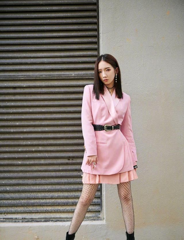 孟美岐舞台造型,身穿粉色系西装搭配皮质腰带,甜美不失飒气