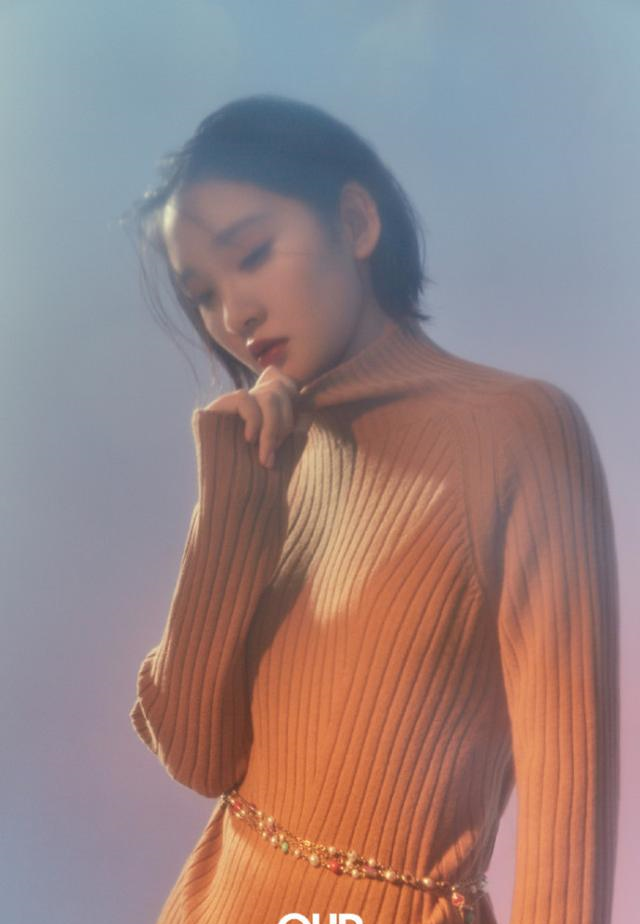 单手托腮,低头凝视的唐艺昕,一个眼神足以让人迷醉,如冬日暖阳一般给