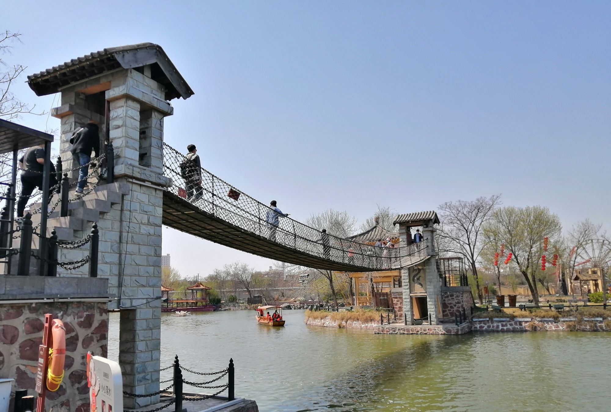 游客纷纷体验开封吊桥,儿童们蹦蹦跳跳,成年人晃晃悠悠