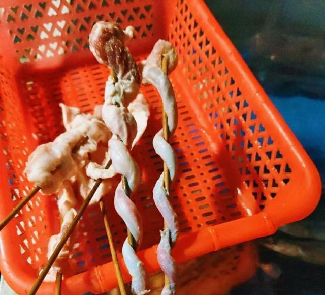 猪鞭刷上一层油,然后放到碳火上烤,边烤边翻转,撒上盐,孜然粉,辣椒面