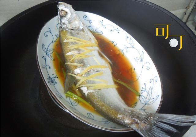 另起锅烧一点滚油淋到葱花上激出香气,家庭版酱油蒸朋鱼就做好了