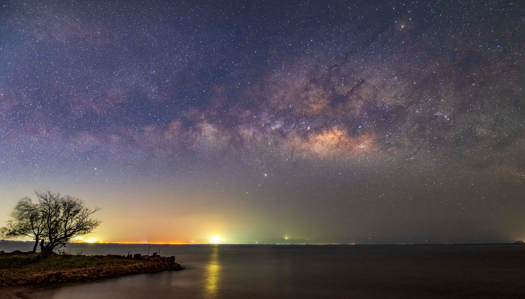 夏季是最适合拍银河的,湖面之上的银河星空与湖畔的灯火交相辉映,格外