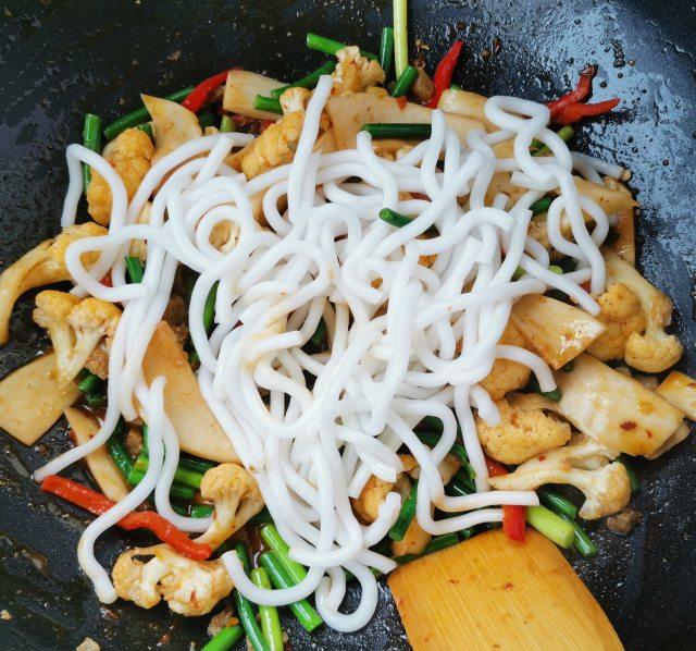 第3步,蒜苔断生后放入手擀粉,调入适量的盐,生抽,十三香.