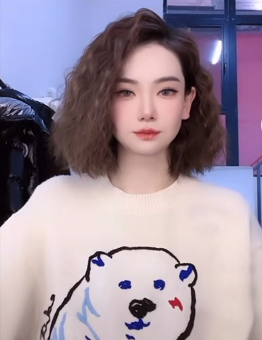视频中戚薇穿了件印有狗熊图案的白色毛衣,齐肩波浪短发很有气质,高挺