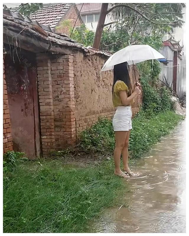 下雨天，女子撑伞站在路边，等待丈夫出差回家休闲区蓝鸢梦想 - Www.slyday.coM