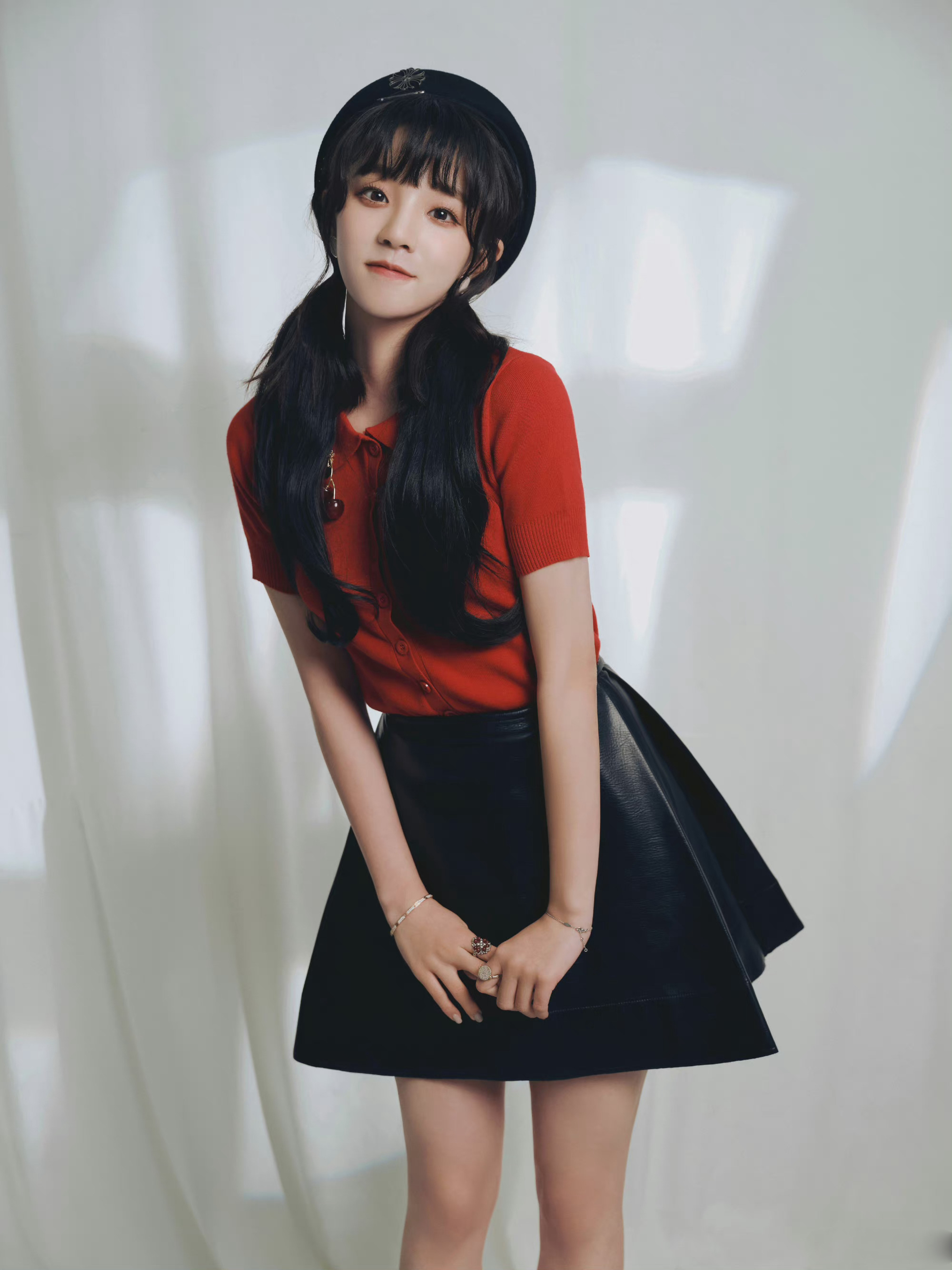 宋雨琦身着橙红色针织上衣和黑色皮裙,搭配黑色皮鞋,复古可爱__财经
