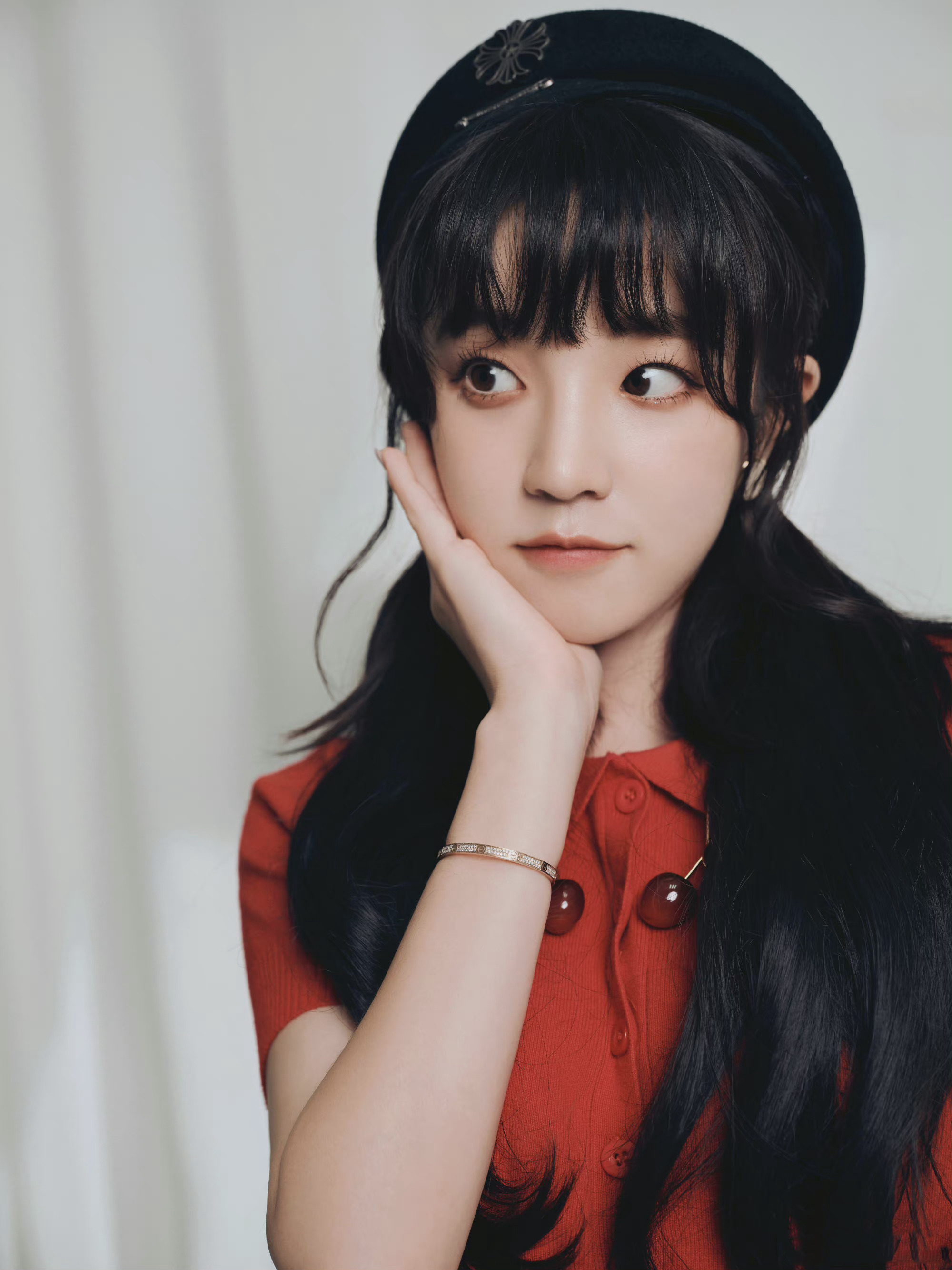 宋雨琦身着橙红色针织上衣和黑色皮裙,搭配黑色皮鞋