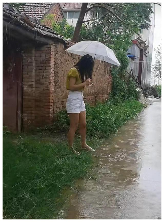 下雨天，女子撑伞站在路边，等待丈夫出差回家休闲区蓝鸢梦想 - Www.slyday.coM