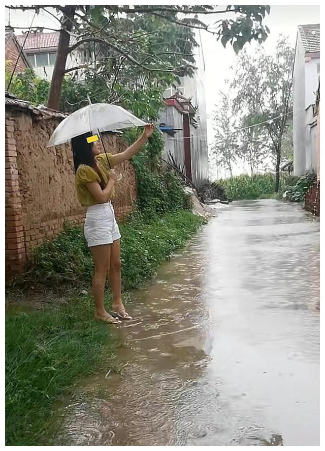 下雨天，女子撑伞站在路边，等待丈夫出差回家休闲区蓝鸢梦想 - Www.slyday.coM