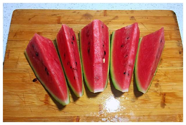 4 把西瓜肉切成三角厚片,整齐的摆放入盘中,围成一个圈!