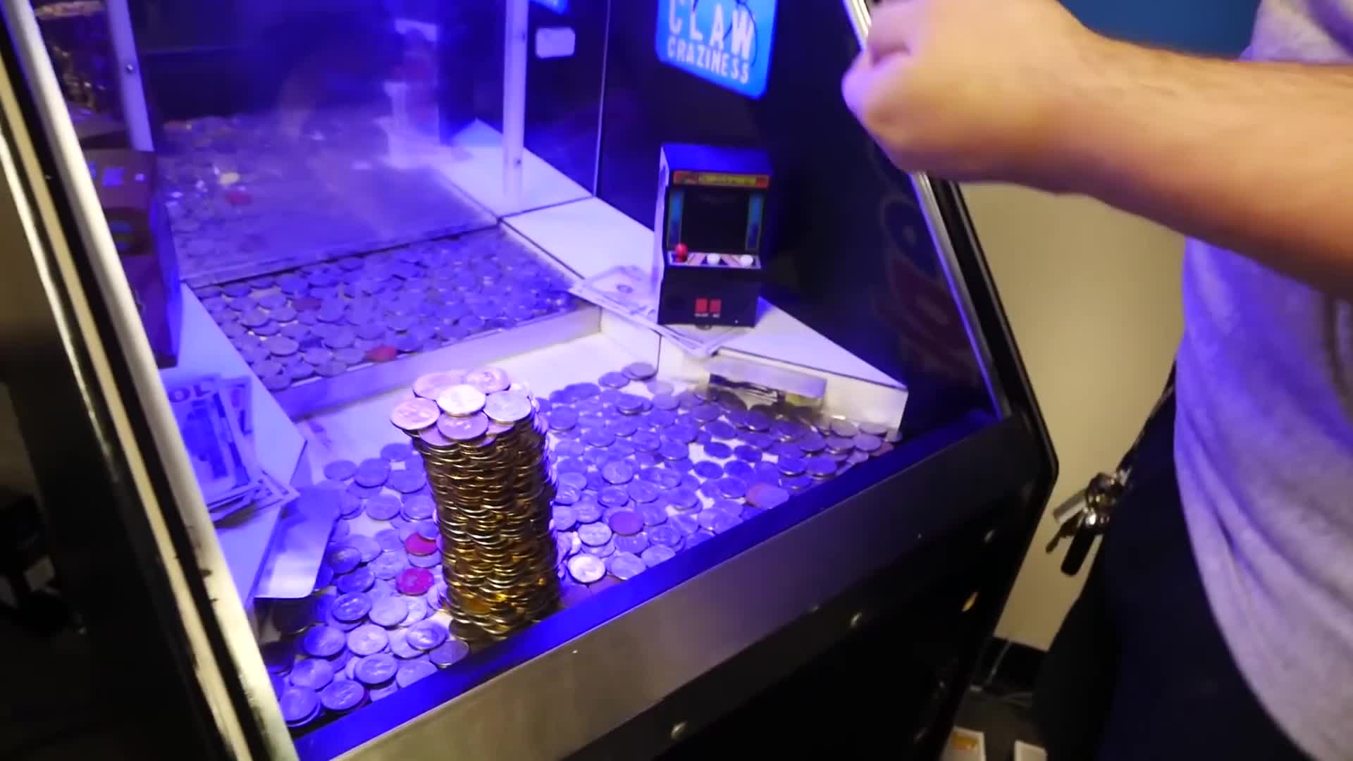 推币机里有8座硬币塔,小伙最后把手伸了进去,将其全部推倒
