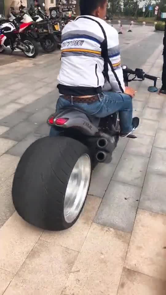 小哥哥骑的这台摩托车后轮宽大声浪浑厚有力