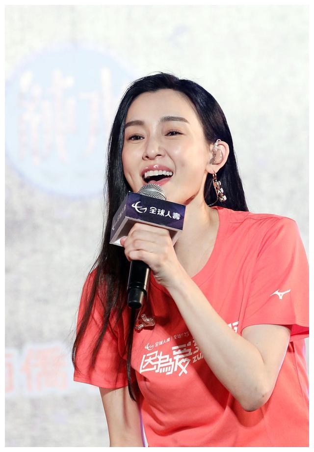 范玮琪穿橘色t恤配牛仔裤休闲时尚,黑色长发披肩女神范十足