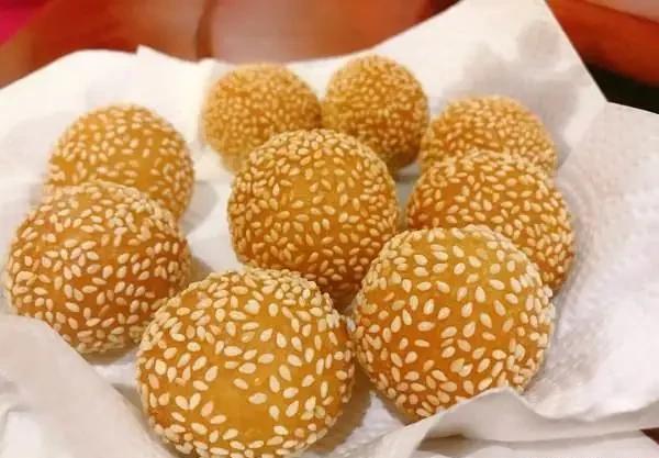 龙江煎堆呈球形(寓团圆之意,有"碌得起"的吉祥意蕴),糯米粉做皮,炸至