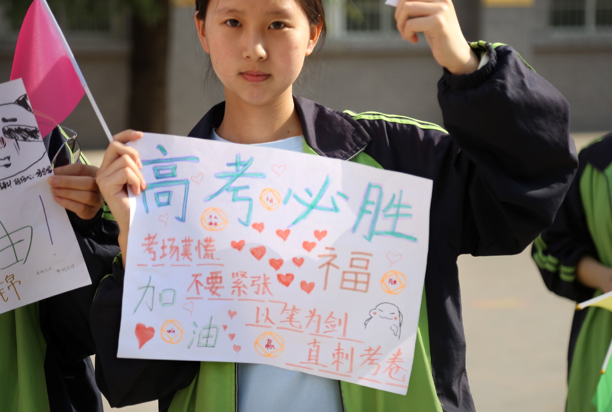 男老师身穿红衣服手拿向日葵,为考生加油,寓意:状元郎一举夺魁|寓意|