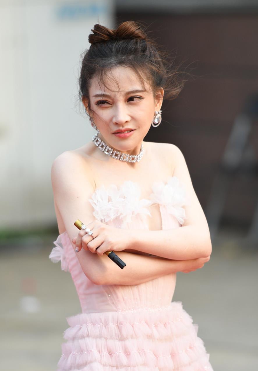 冯提莫穿粉嫩深v裙秀身材 遇大风抱紧自己