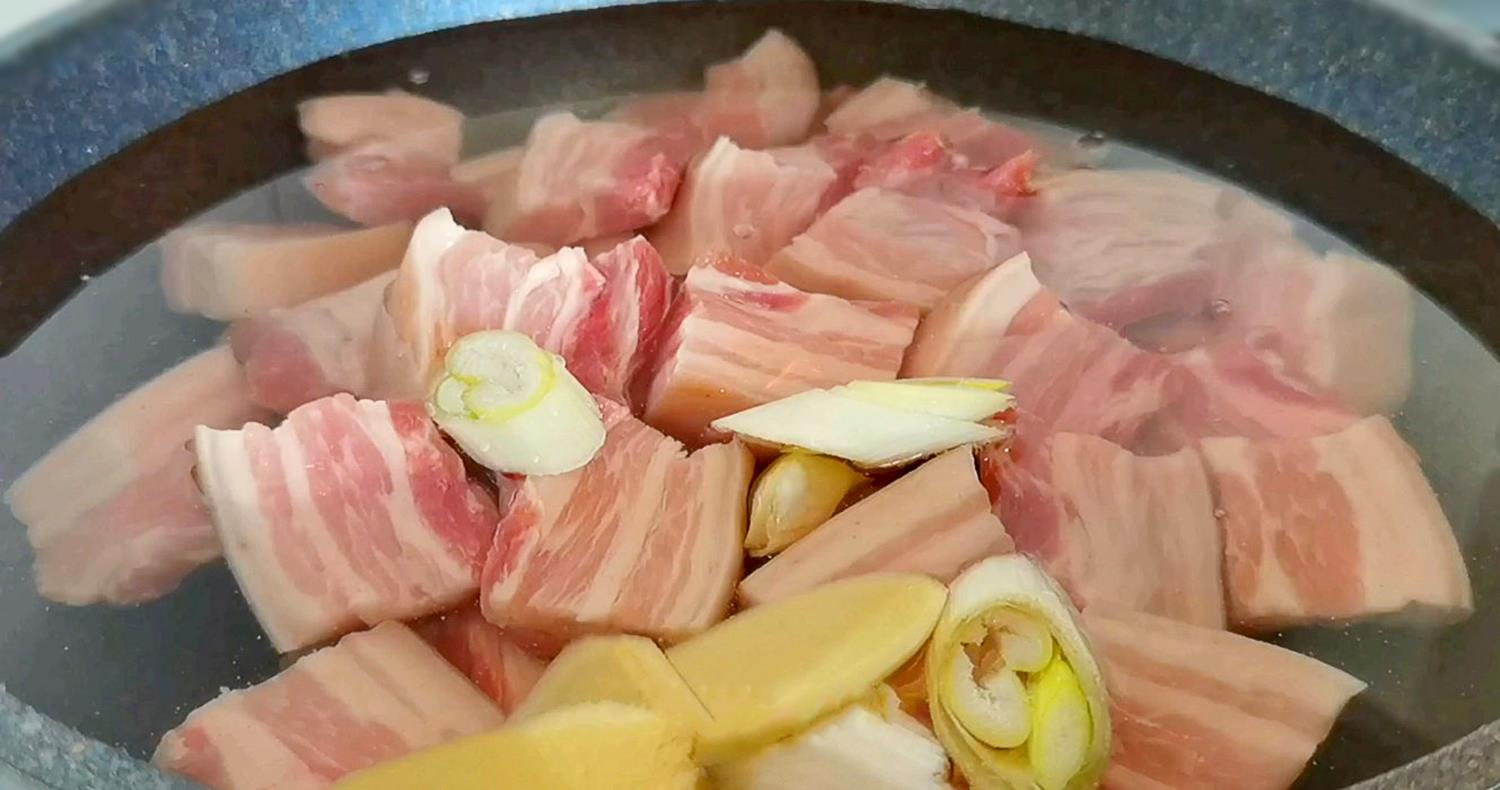 4,五花肉焯水完成后,捞出来控水,用清水冲洗下,去除表面的浮沫.