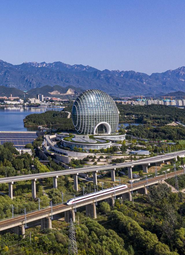 粉色涂装s516次怀密号动车组列车驶过雁栖湖畔