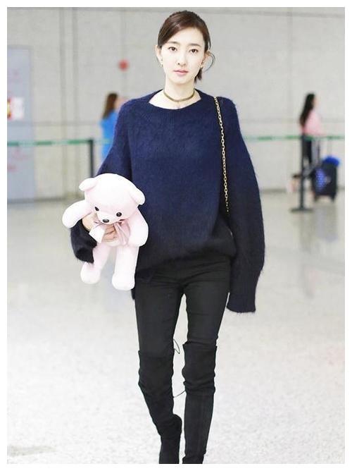 下图照片中,王丽坤穿了一件白色高领针织衫搭配浅蓝色牛仔宽松长裤,外