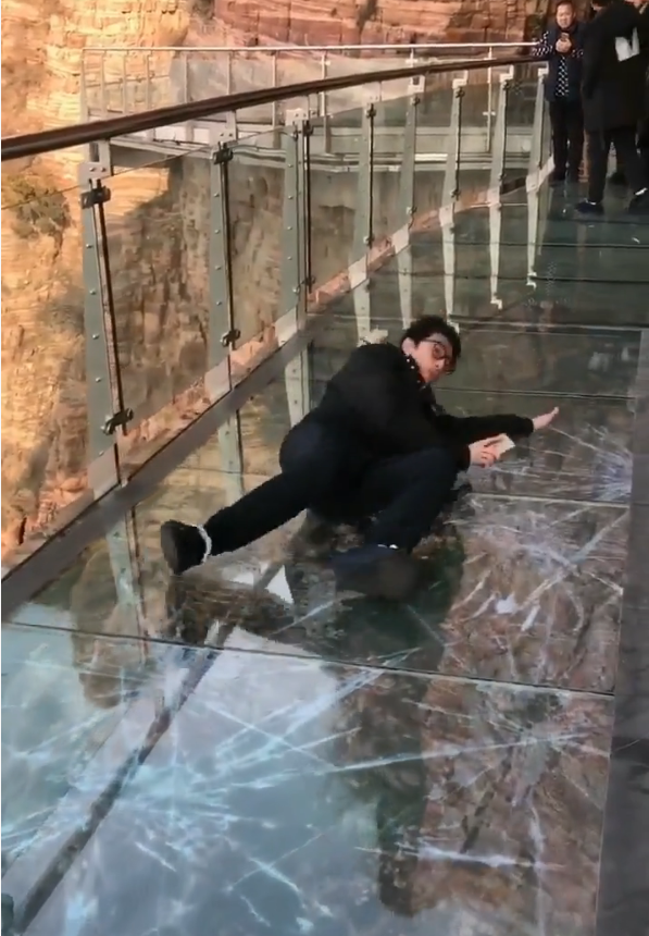 男子被突然破碎的玻璃栈道吓住接下来的动作引来旁边人大笑