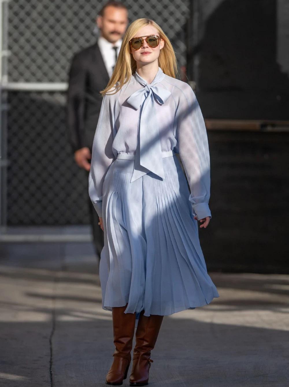 艾丽·范宁街拍照,身着蓝色连衣裙,蝴蝶结少女风十足