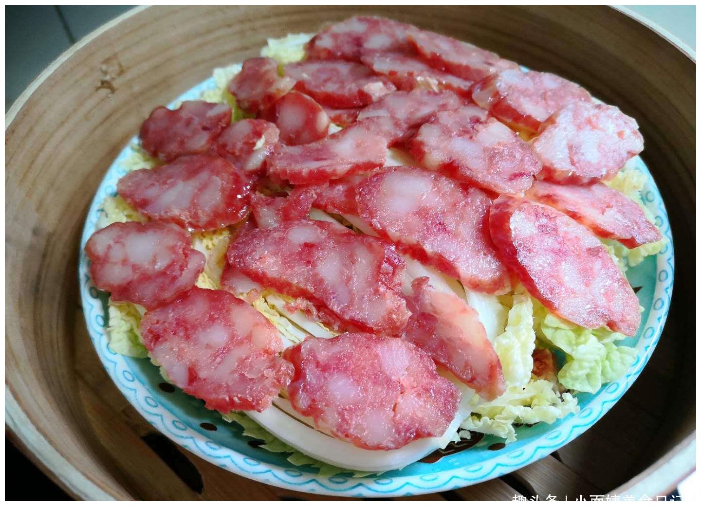 5,蒸锅提前把水烧开,白菜上面放上切成片的腊肠,放入蒸锅,盖上锅盖.