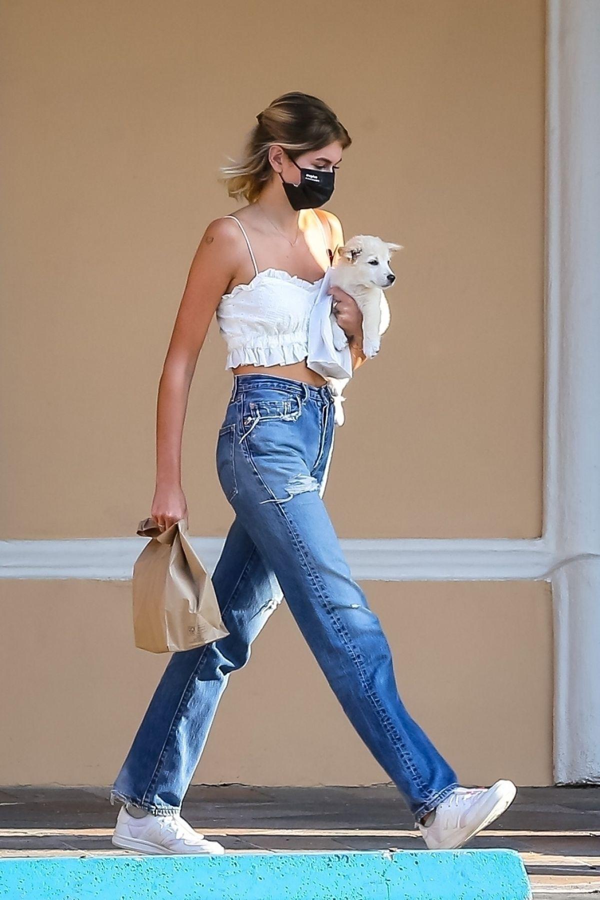 凯雅·杰柏抱狗外出,吊带搭配牛仔裤,超长美腿大步流星