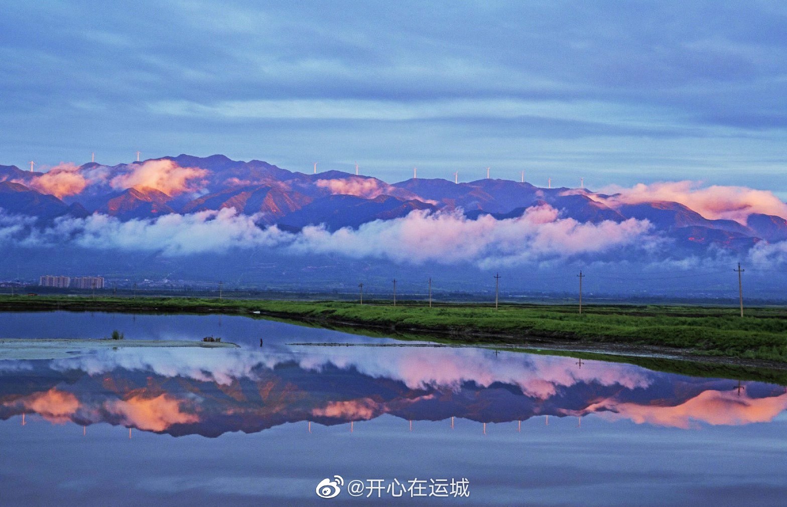 连续降雨初晴后山西运城盐湖在云雾缭绕中条山的映衬下