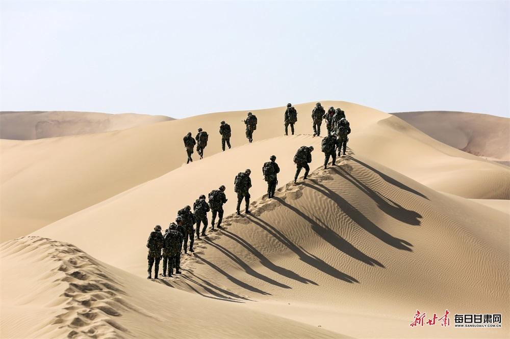 特战队员负重30公斤抢占沙漠坡顶.特战队员在沙漠中冲刺.